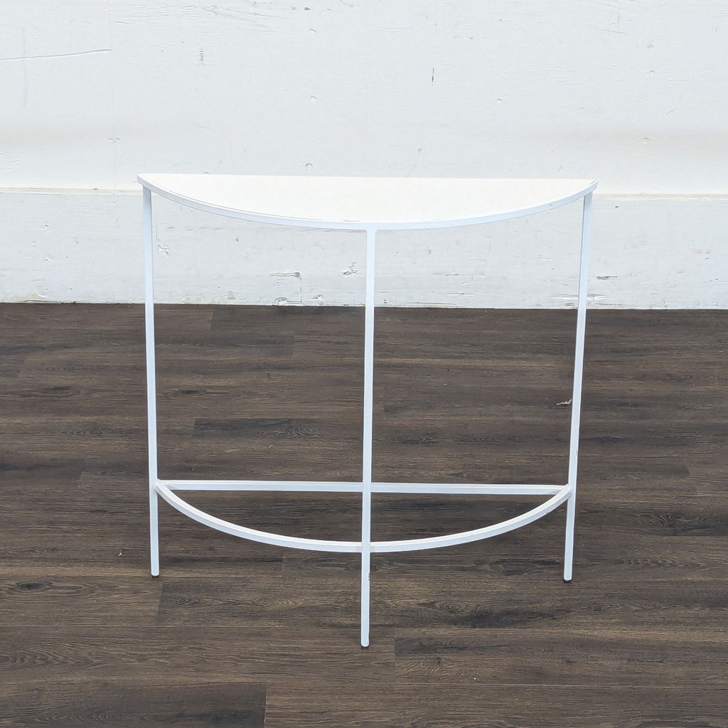 2. Modern Reperch brand table in a semicircular shape, white frame and top, on dark wood flooring.