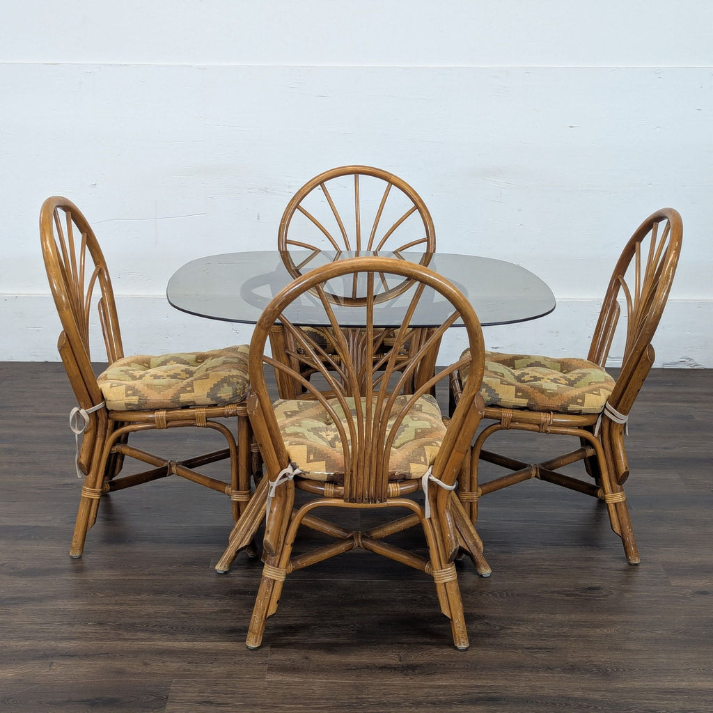 2. Four vintage rattan chairs with geometric cushions surround a glass-top dining table, brand Reperch.