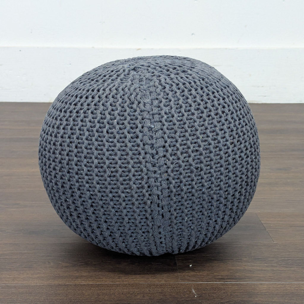 1. Round gray knit ottoman from Reperch, placed on a wooden floor, ideal for modern seating or decor.