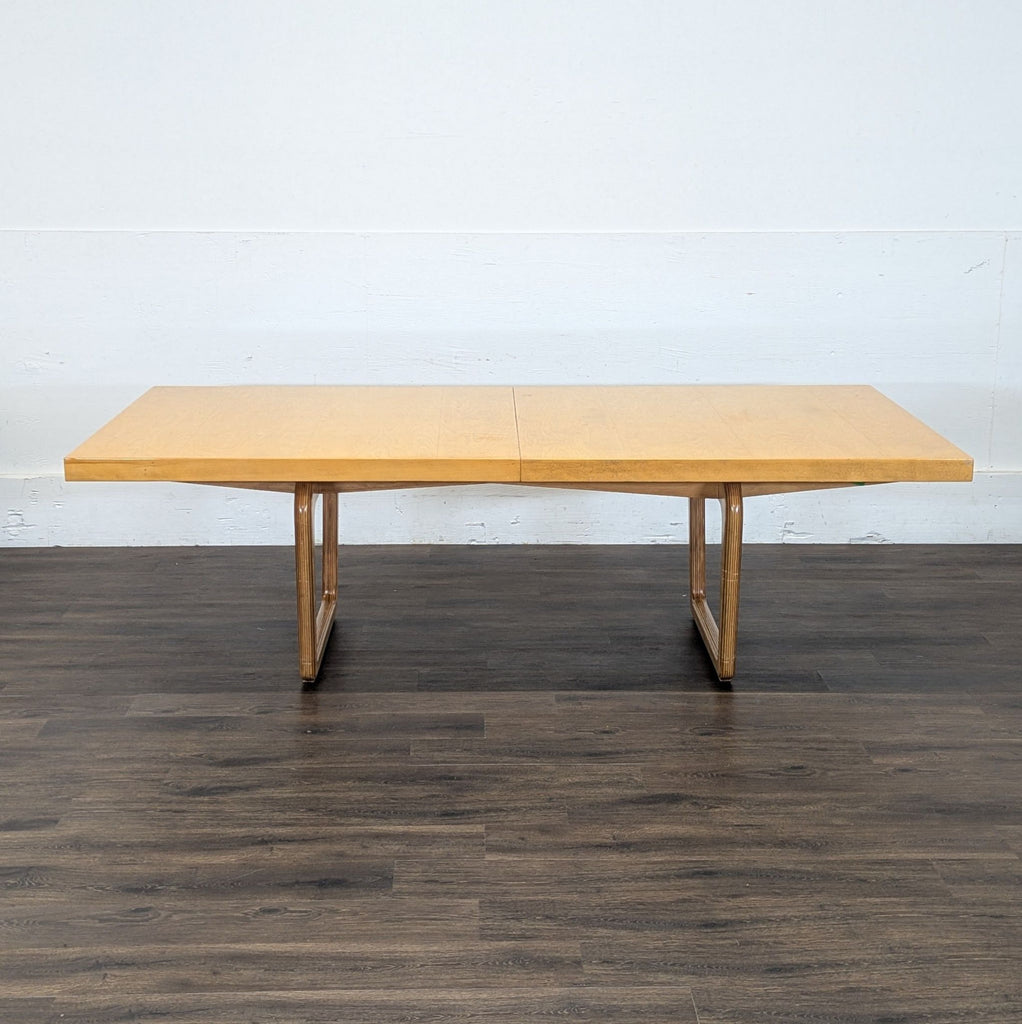 3. Large rectangular Reperch dining table with leaf, in light wood, displayed in an empty room.