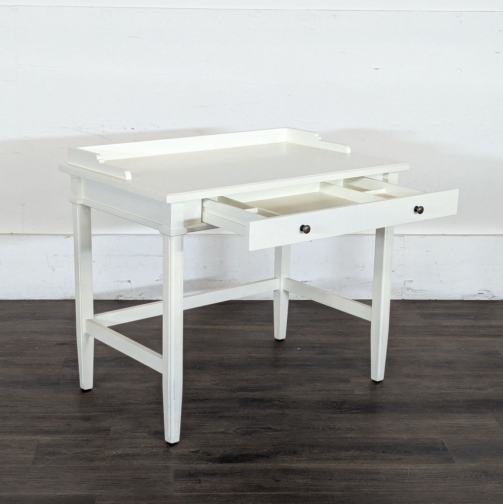 3. White Reperch desk with its central drawer open, featuring two compartments and simple round knobs.