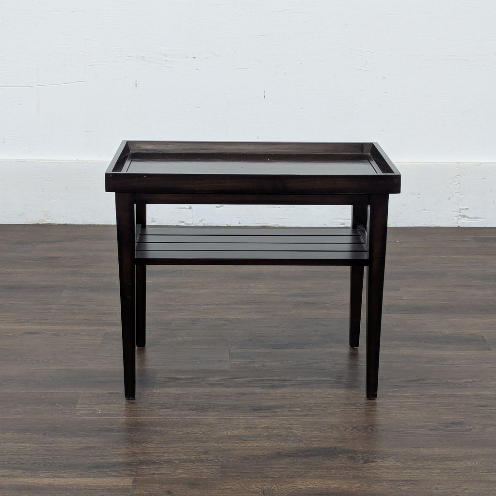 1. Dark wooden Reperch side table with raised edges and slatted lower shelf, shown from the front.