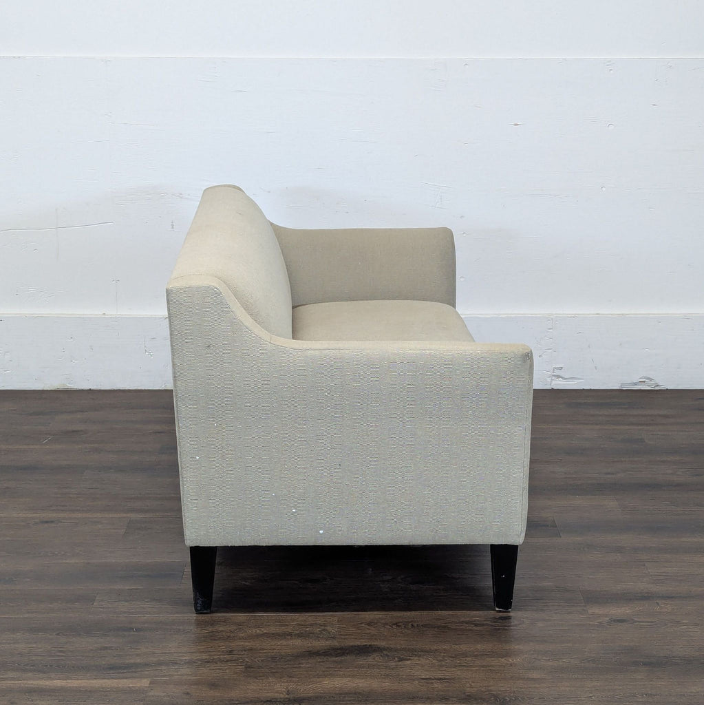 3. Side profile of a Reperch loveseat in beige upholstery, emphasizing its sleek arm and sturdy legs.