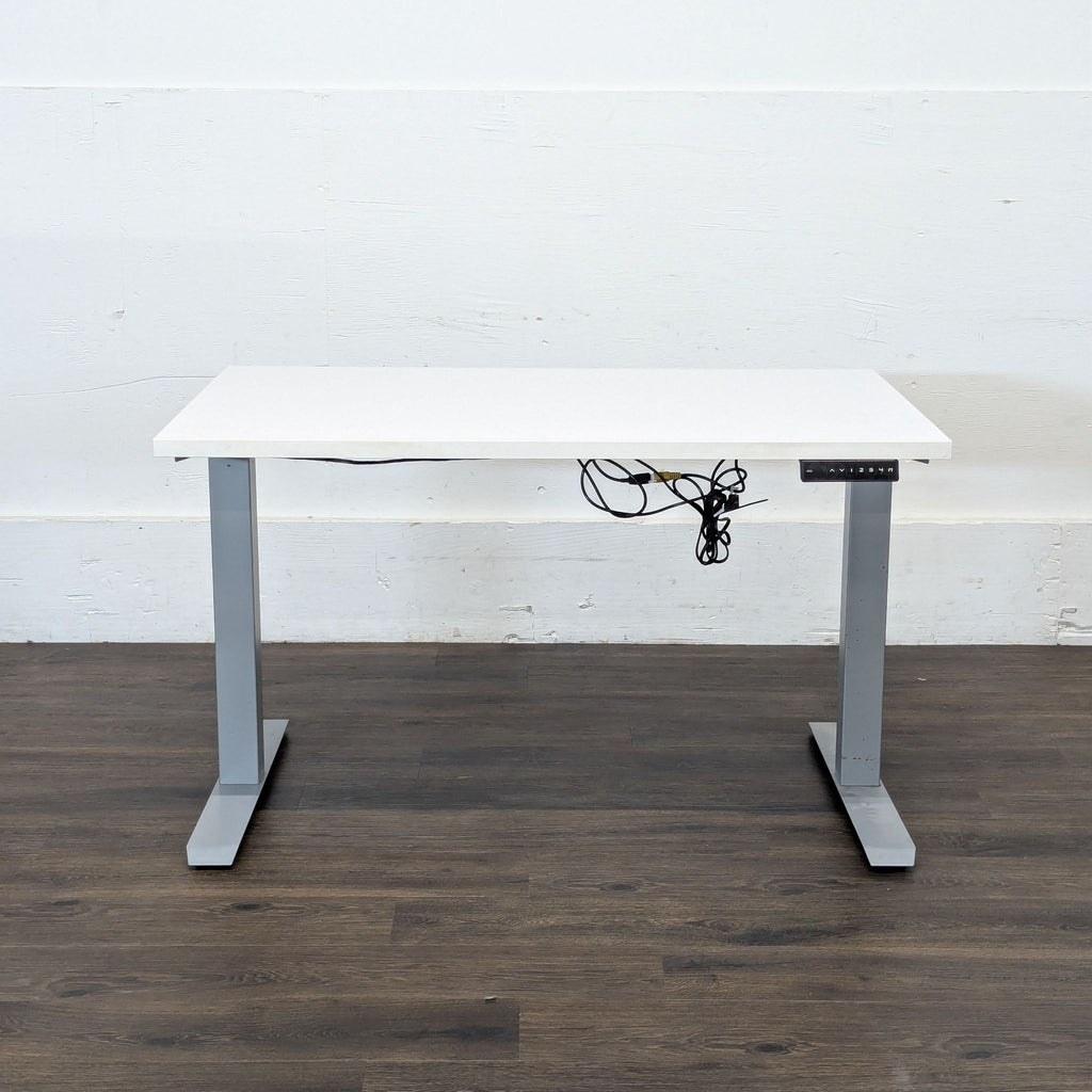 2. Reperch standing desk with a white top, grey legs, and visible cords, shown against a white wall.
