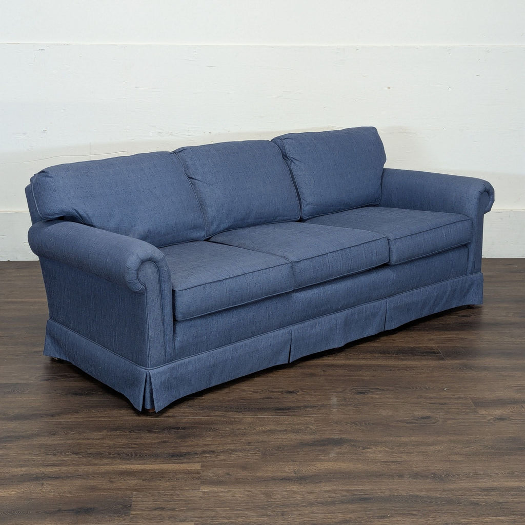 3. Angled view of a blue Reperch 3-seat sofa with classic design on a wood floor and white background.