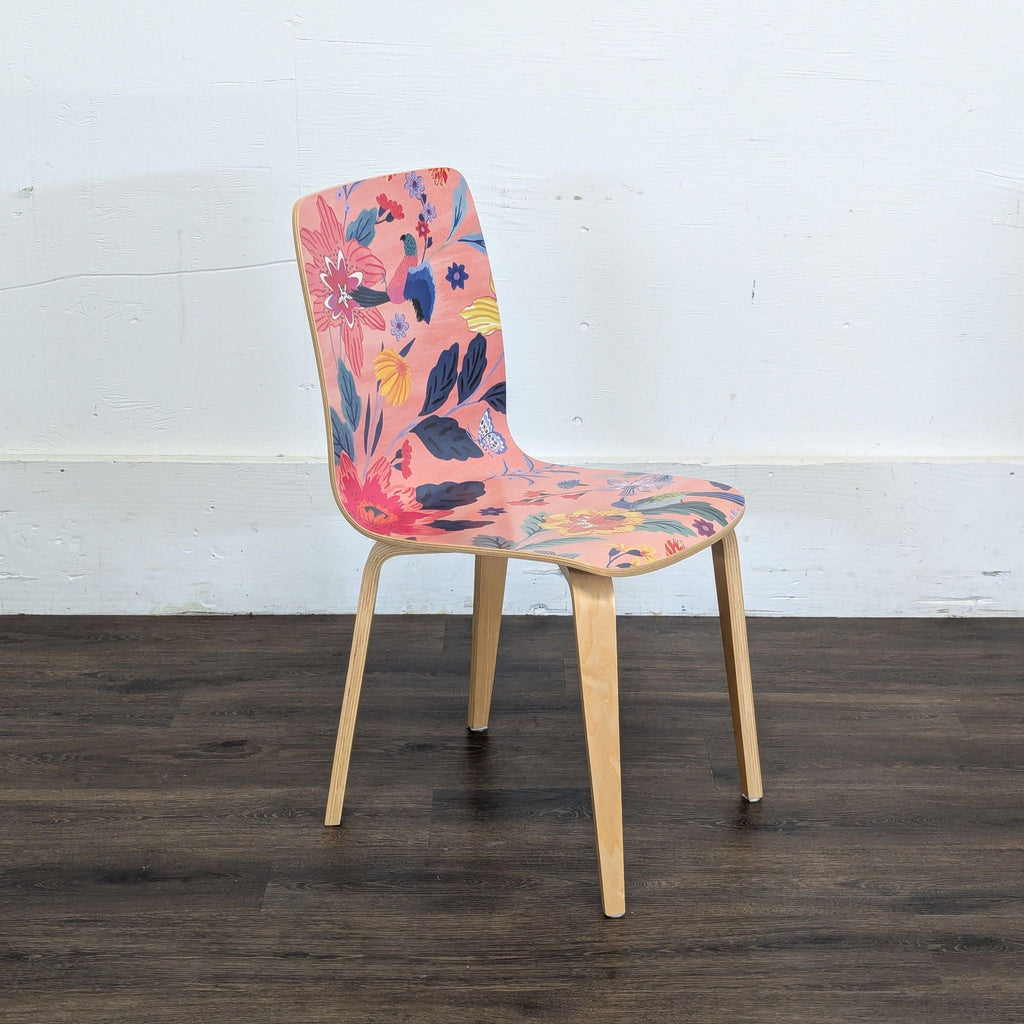 2. Side view of a Reperch dining chair with light wood legs and colorful pink floral patterned seat and back.