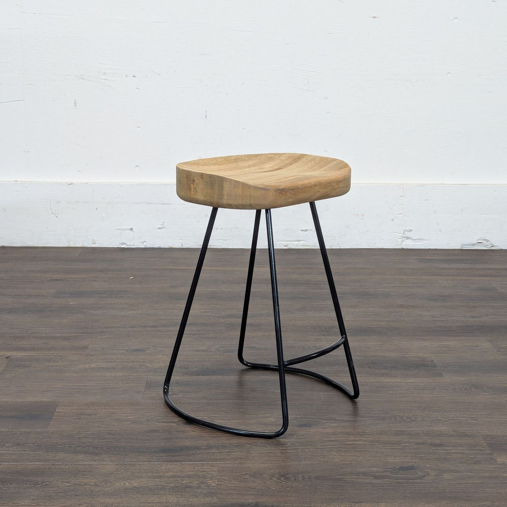 3. Restoration Hardware stool with curved wooden seat and slender metal frame, suitable for versatile seating needs.