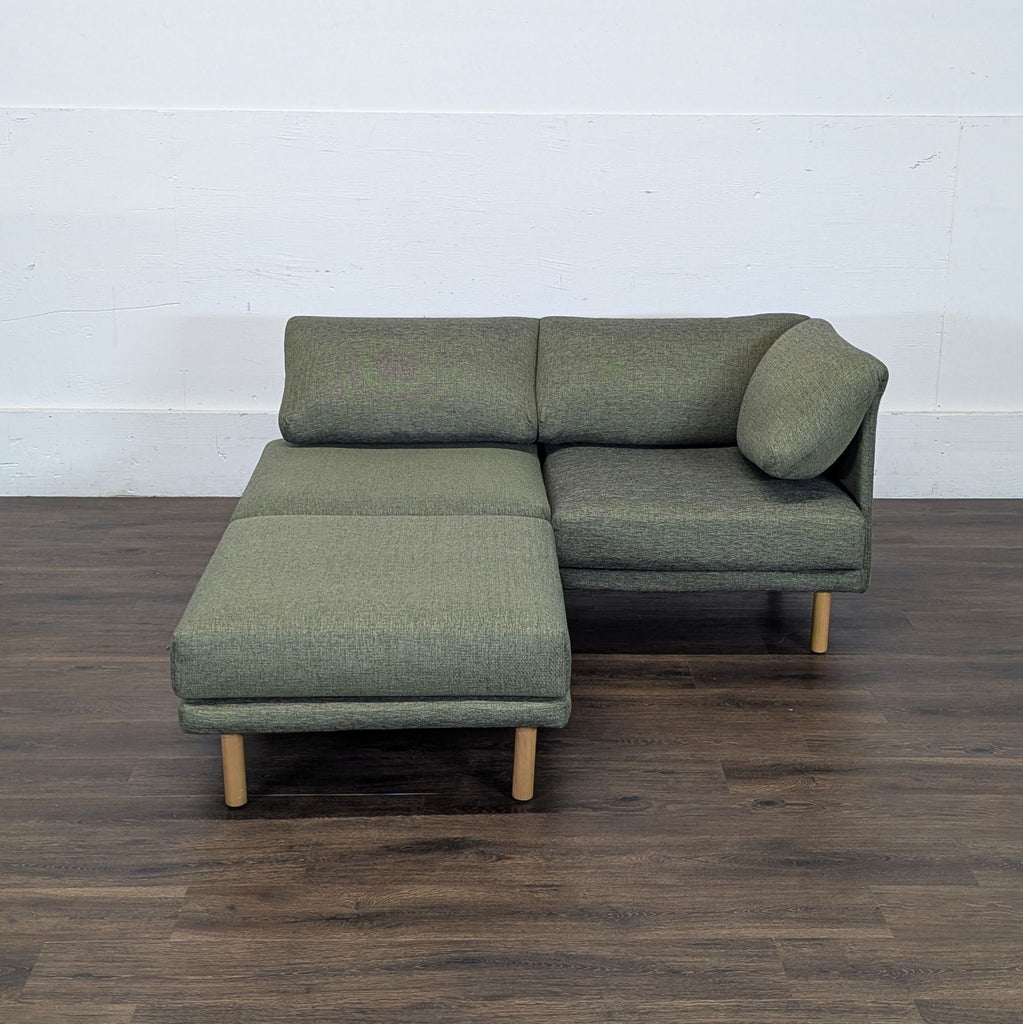 3. Compact Reperch 3-seat sofa in green upholstery with wooden legs, set up as a chaise lounge on wooden flooring.
