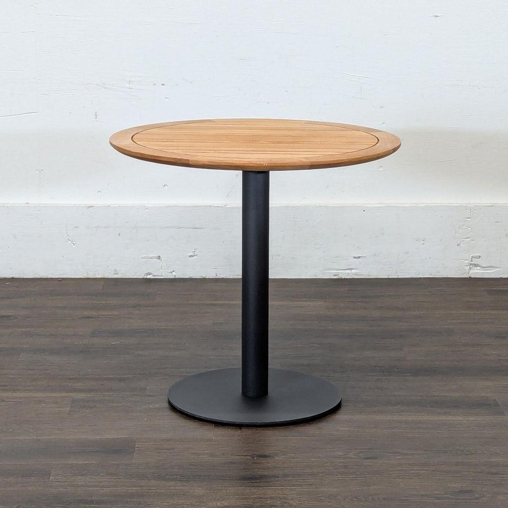 2. Reperch brand round side table with a slatted wood top and sturdy black pedestal base, on wood floor.  