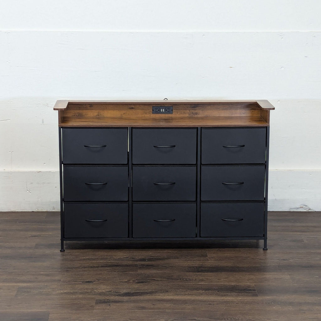 2. Front view of a cabinet with black drawers and a wood finish top, including integrated power outlets.  