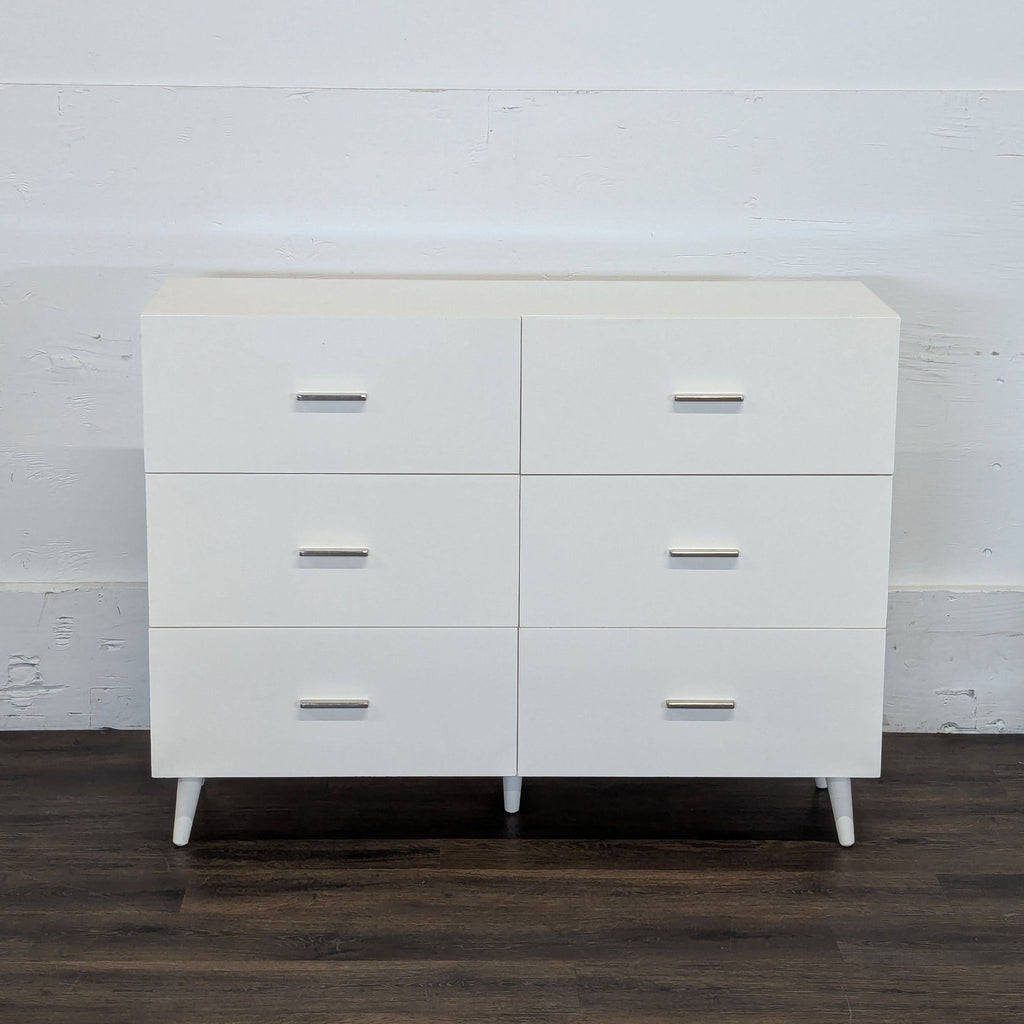 3. Minimalist Westelm six-drawer white dresser with metal handles, displayed against a plain wall.