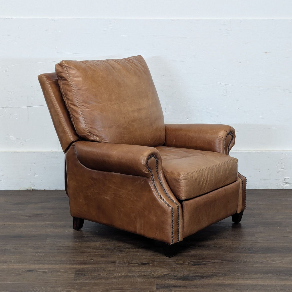 3. Pottery Barn leather lounge chair with plush cushioning, rolled arms, and nailhead trim, viewed from an angle.