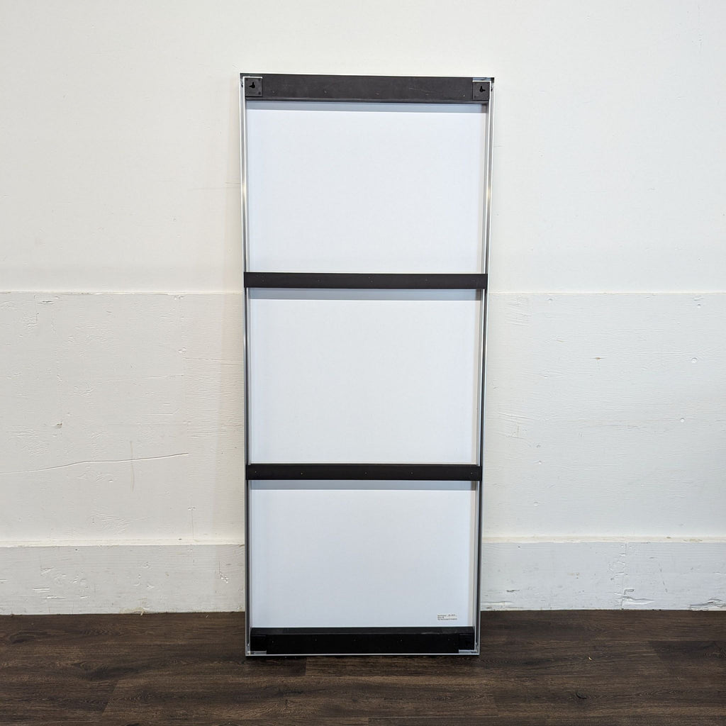 3. Rear view of a Reperch mirror showing three horizontal mounting bars and a sleek silver frame against a wall.