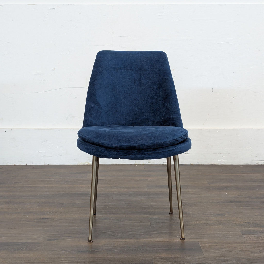 3. West Elm navy blue dining chair with plush seat cushion and slender gold legs, shown against white wall.