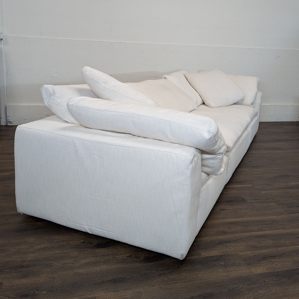 2. Angled side view of a white Reperch sectional sofa highlighting its overstuffed arms and soft pillows.  