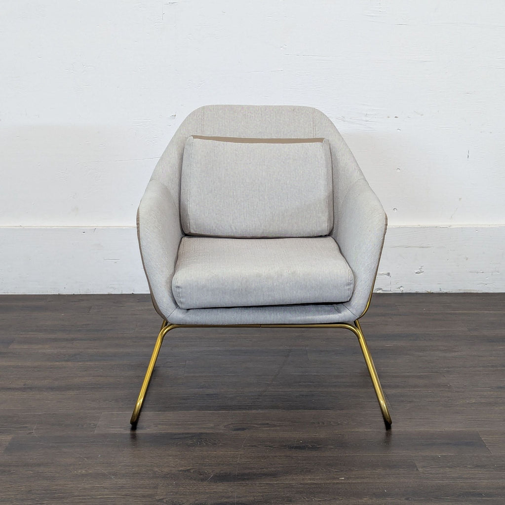 2. Reperch lounge chair with light grey fabric, gold metal legs, and a matching back cushion on wood flooring.