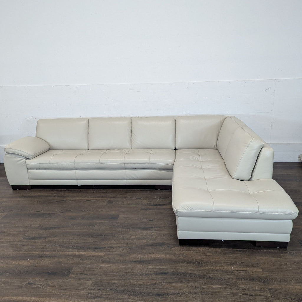 2. Reperch sectional sofa in light gray leather, shown against a plain wall on dark wooden flooring.
