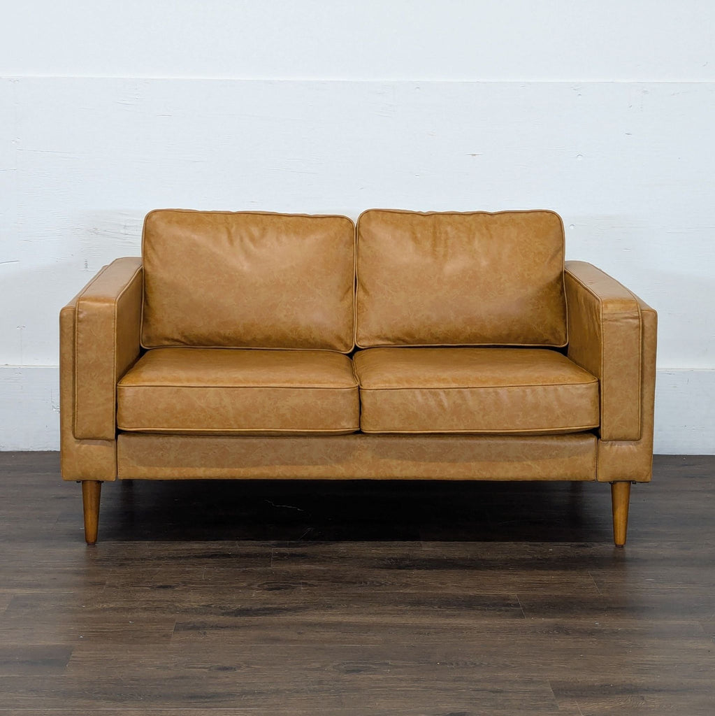 2. Albany Park tan loveseat, mid-century modern design, shown against a plain white wall on wooden floors.