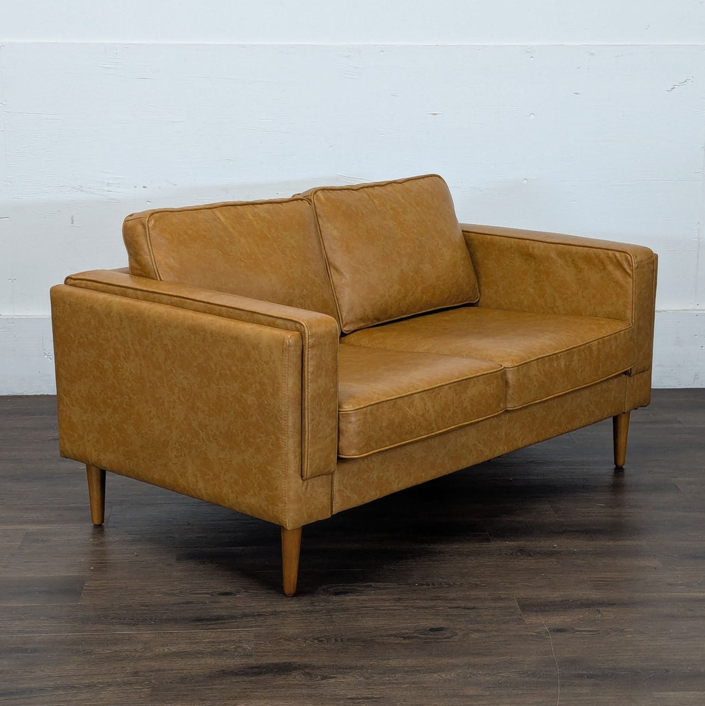 3. Tan Albany Park loveseat, angled view highlighting its clean lines, modern arms, and wooden legs on dark flooring.