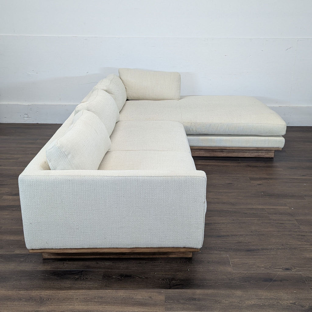 3. Side view of the Reperch sectional, highlighting its clean lines, textured upholstery, and wooden base.