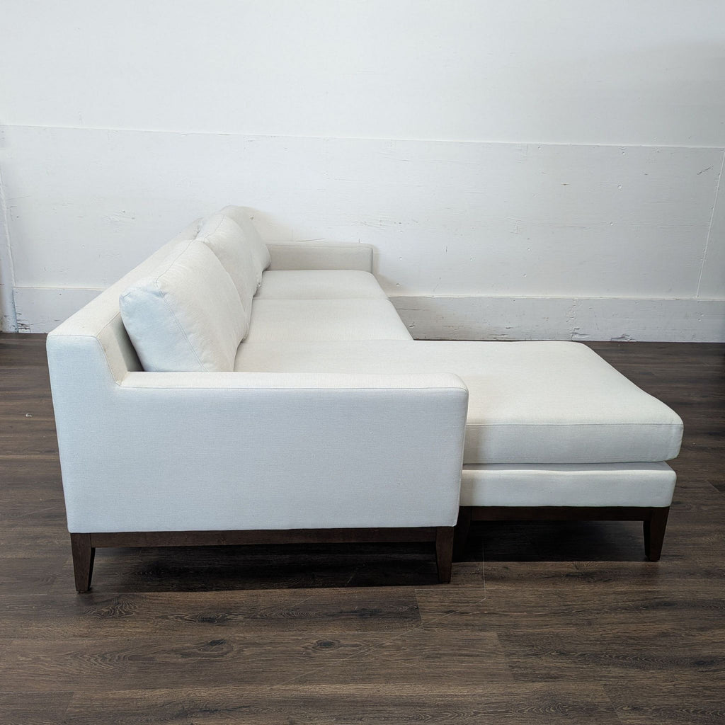 2. Side profile of the Reperch sectional, showing clean lines, light upholstery, and wooden legs.  