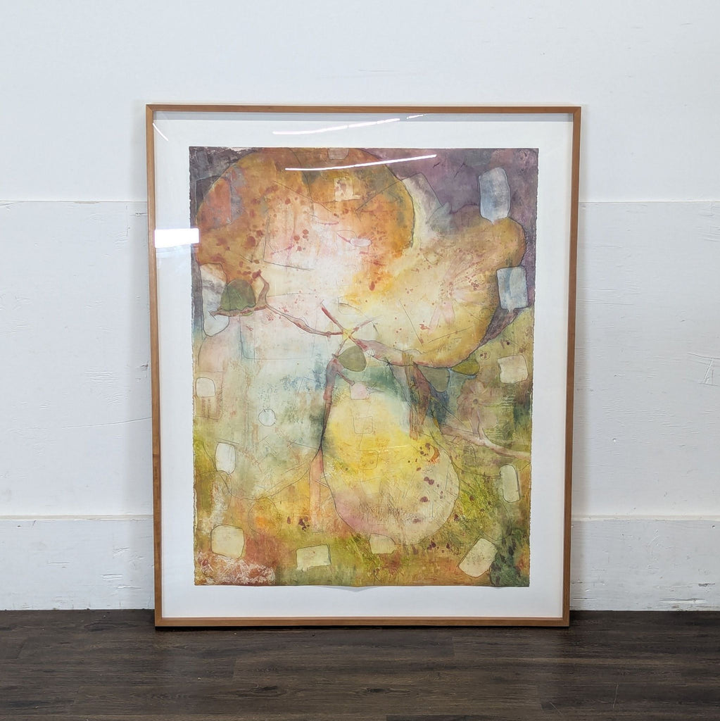 2. Framed Reperch artwork with abstract, muted yellow, orange, and green hues, leaning against a white wall.  