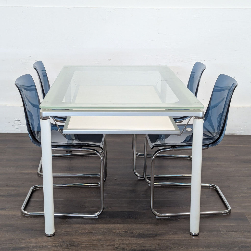 2. Side view of Reperch dining set with glass-top table and four blue chairs with chrome legs.  