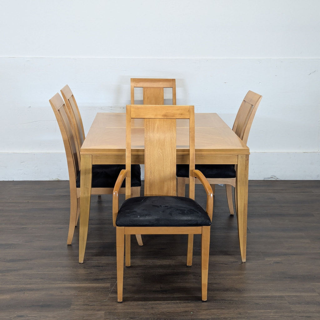 Front view of Ethan Allen dining set; light wood table and chairs with armrests and black cushions on dark wood floor.