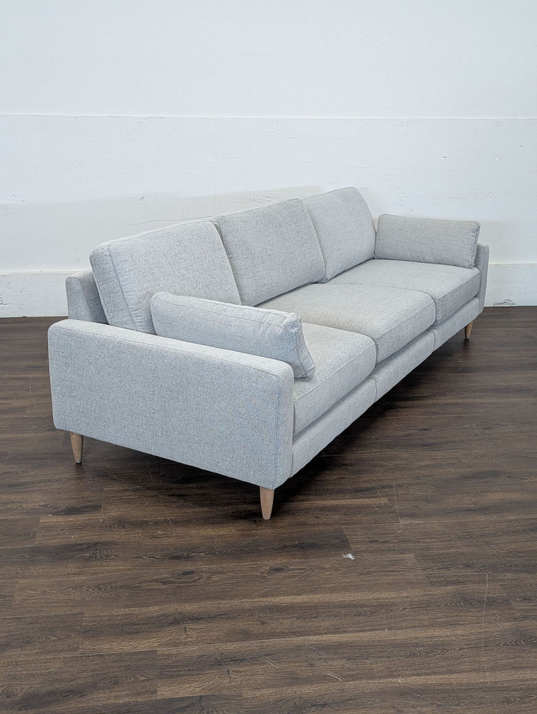 Close-up of Burrow's crushed gravel chenille fabric with sturdy wooden legs.