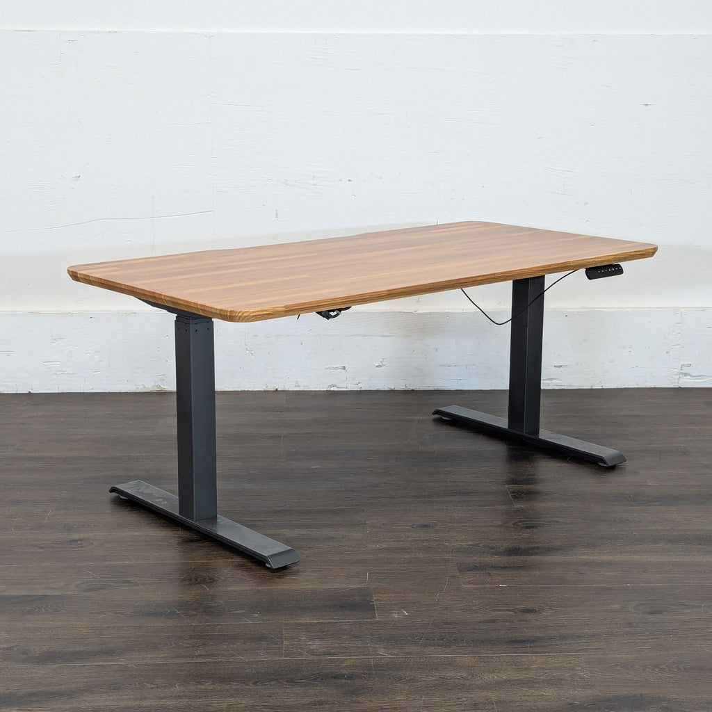 3. Side view of a Varidesk height-adjustable desk featuring a rectangular wood surface and sturdy black metal legs.