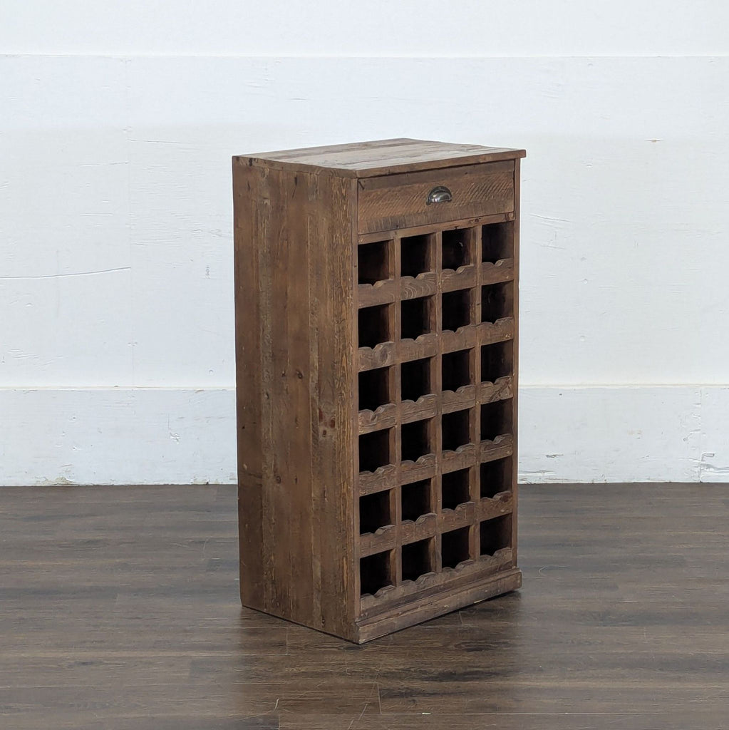 3. Angled view of a Pottery Barn wooden wine rack cabinet, featuring a drawer and grid-style bottle storage slots.