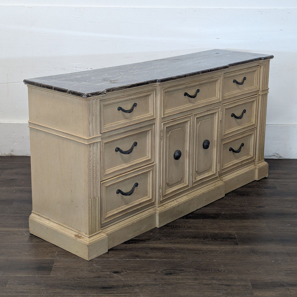 3. Angled view of Stanley Furniture dresser, light wood, marble top, ornate handles, and paneled central doors.