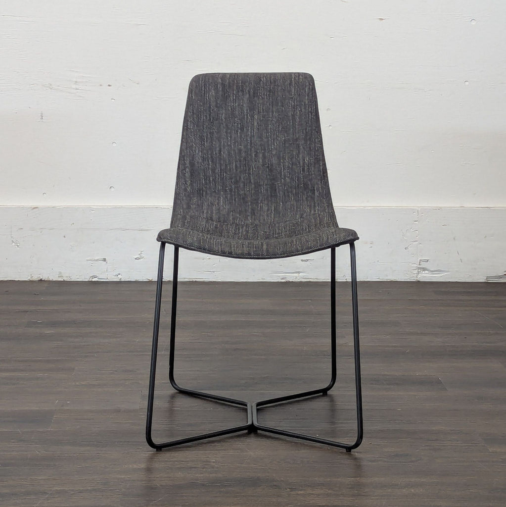 3. Single West Elm dining chair in dark gray fabric with slim black metal legs, displayed against a white wall.