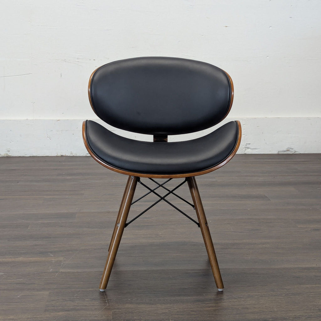 3. Single Armen Living dining chair with black cushioned seat and back, wood trim, and angled wooden legs.