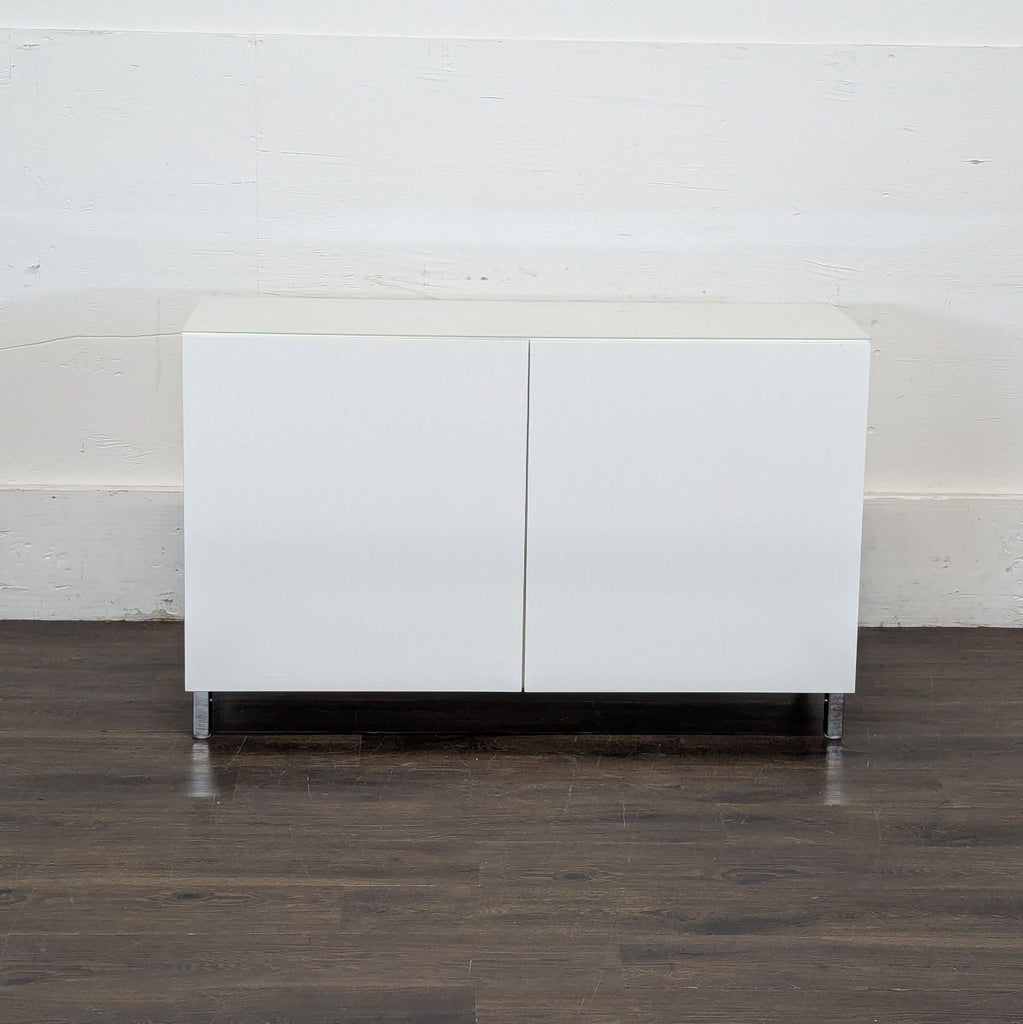 2. Minimalist Ikea cabinet in white, featuring metal legs and a smooth, modern design.