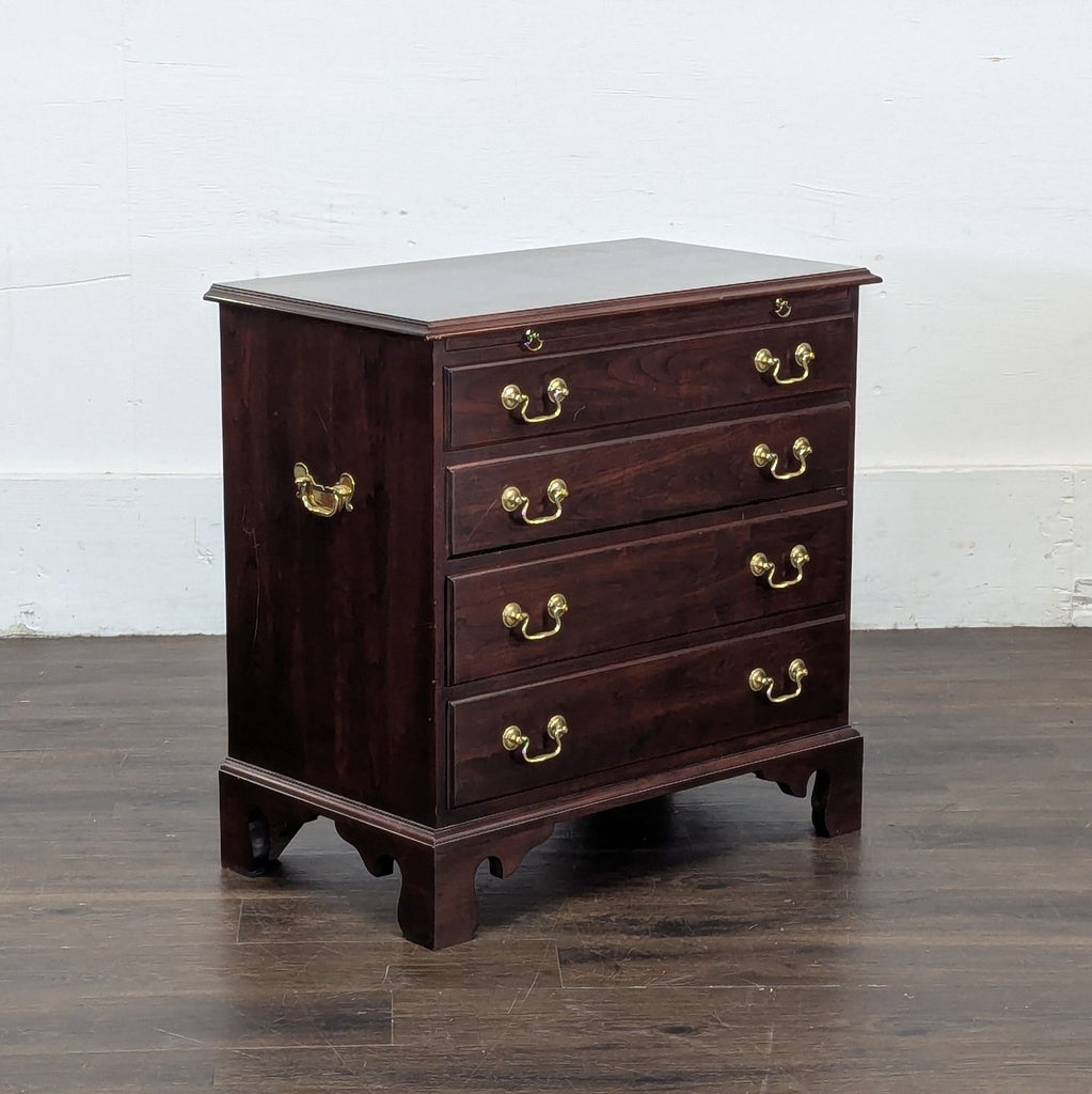 3. Angled view of a Stickley end table in rich wood finish, brass hardware, and bracket feet against a plain backdrop.