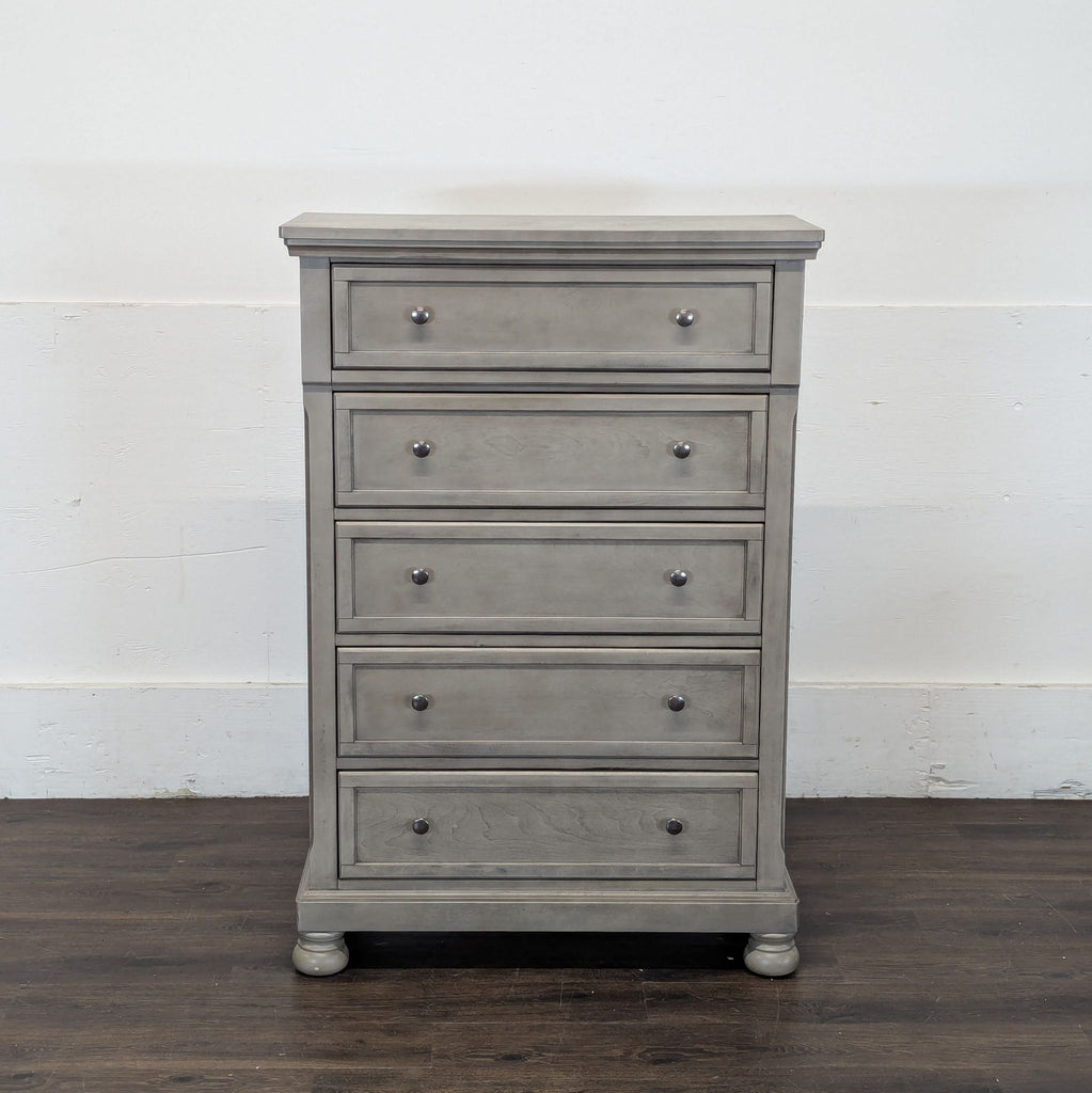 2. Tall Ashley Furniture dresser in gray finish, five-drawer design, simple lines, and traditional styling.  