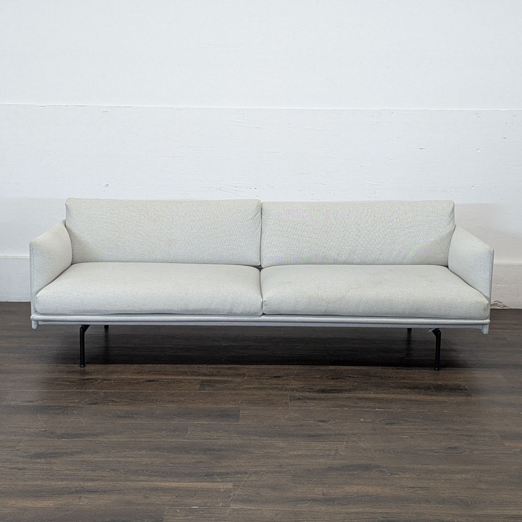 2. Sleek gray Outline sofa, a contemporary loveseat from DWR, featuring clean lines and metal legs.  