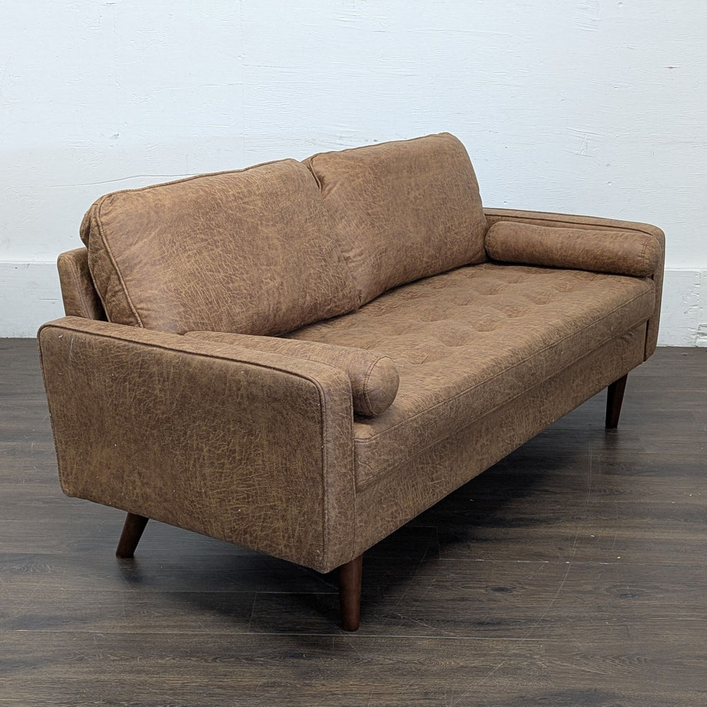 Angled view of an Avantio brand brown 3-seat sofa on wooden legs, featuring rounded arm bolsters.