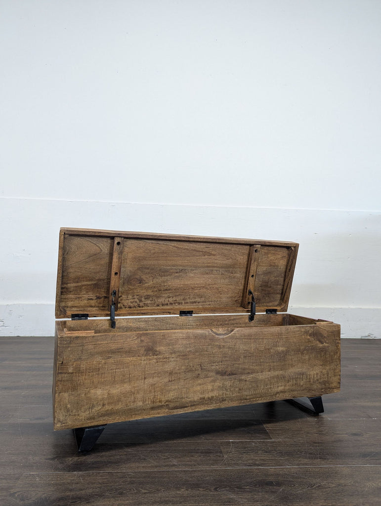 2. Wooden trunk from brand P, shown open to reveal spacious interior storage and sturdy black legs.