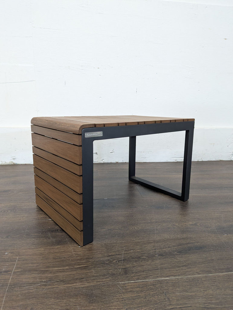 Sleek accent table by Crate and Barrel, featuring a compact design, wood slats, and sturdy black metal legs.