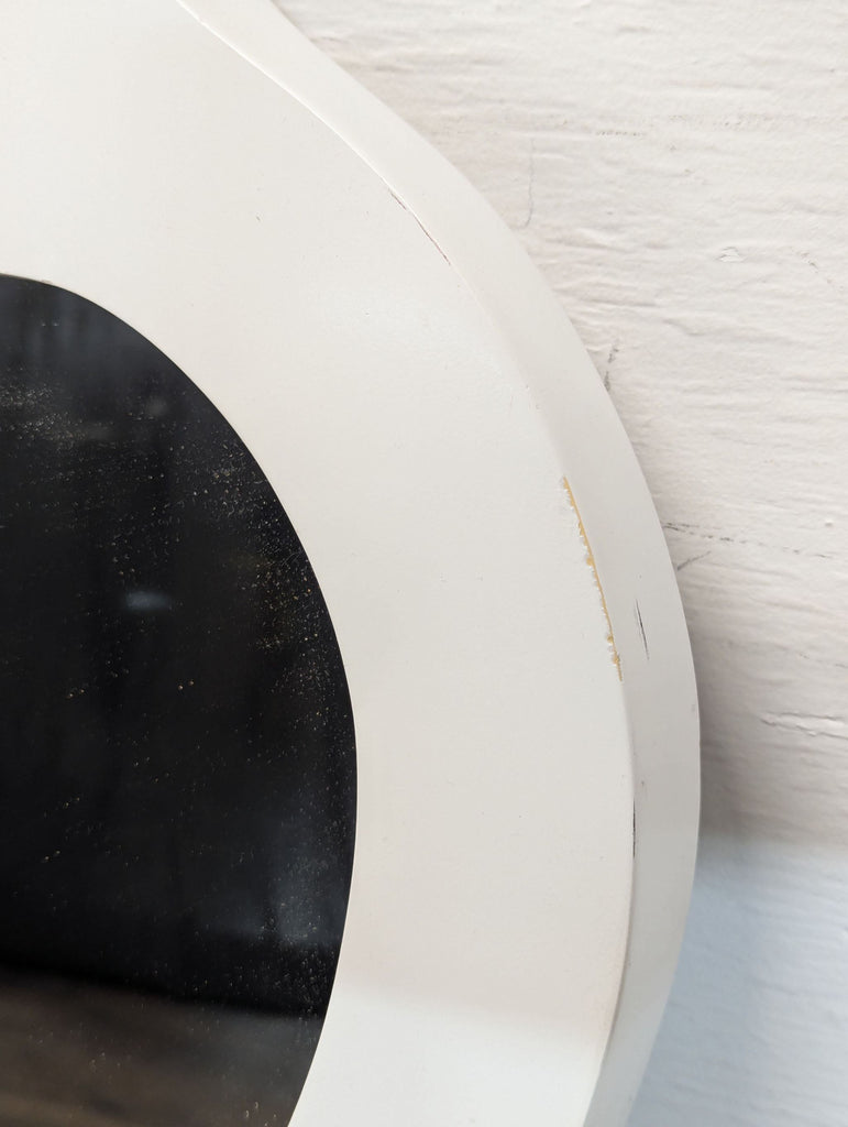 2. Close-up showing a scuff and minor wear on the white frame of the decorative mirror.