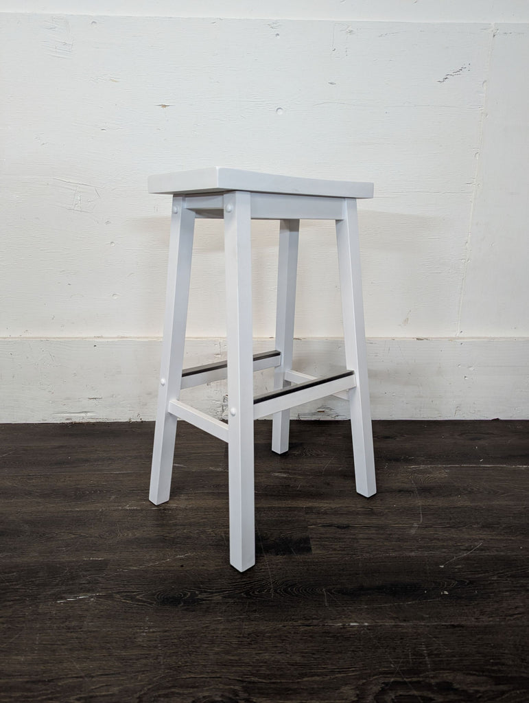 3. Angled view of a white bar stool featuring square legs, a flat seat, and a metal footrest.