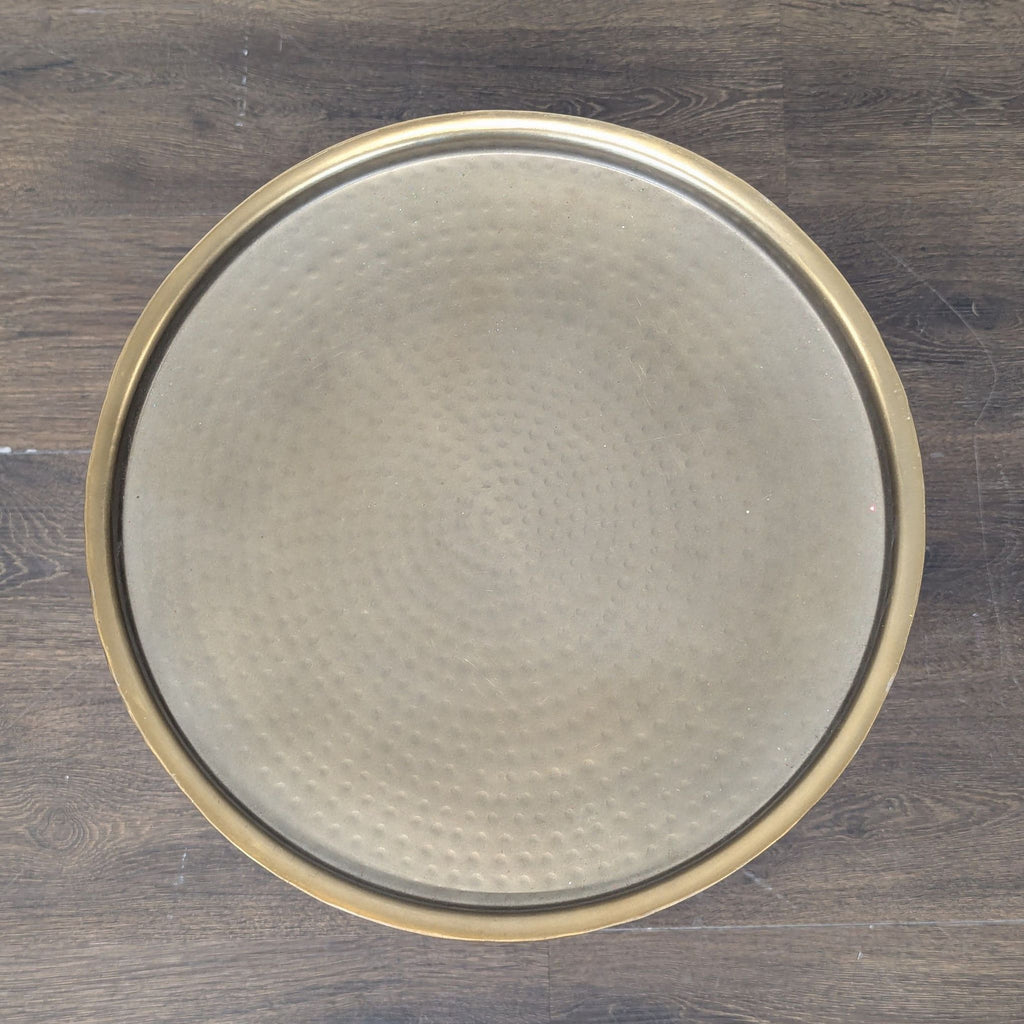 2. Compact round end table with metal legs and a glass surface, holding a small potted plant.