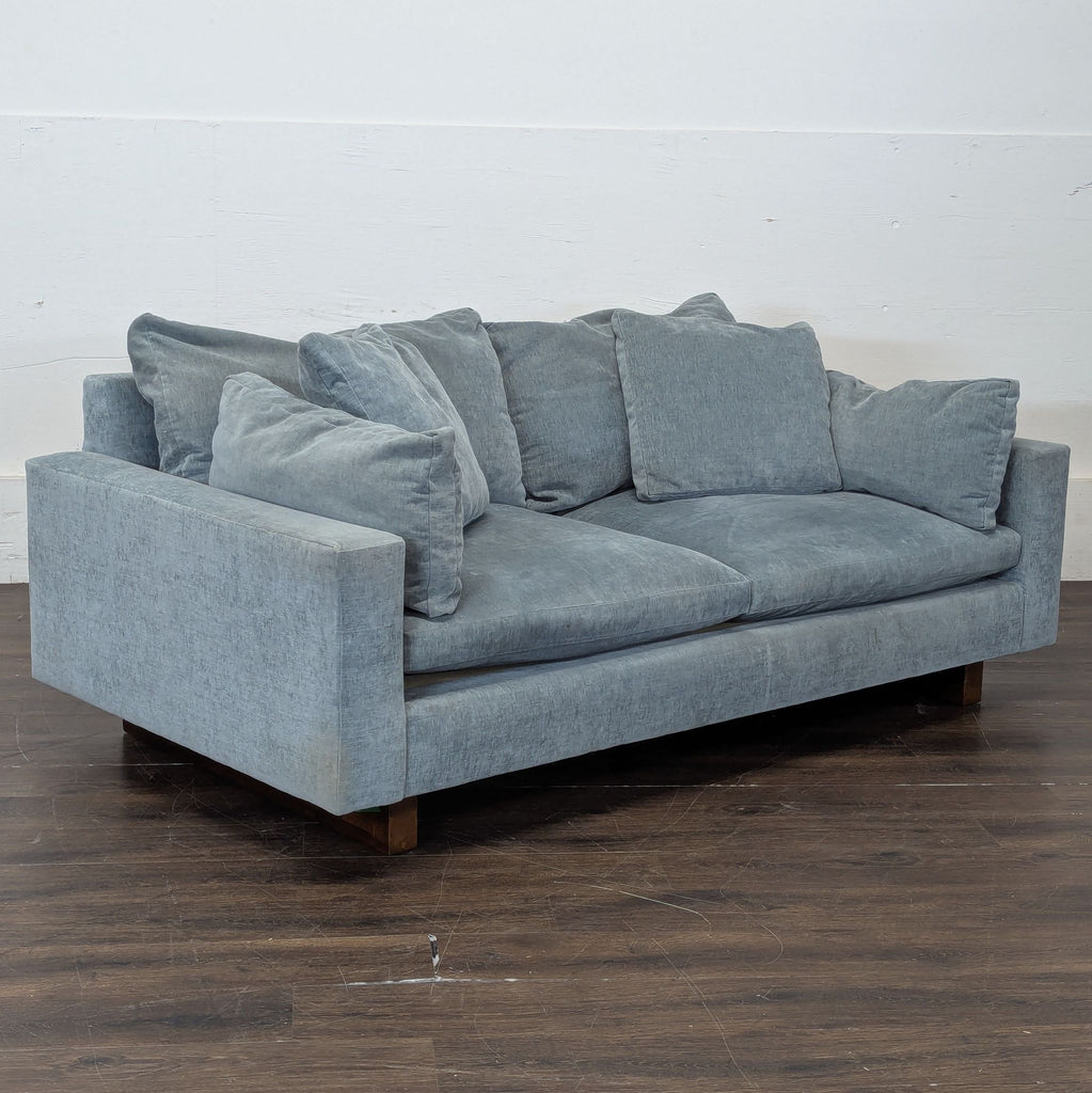 2. Contemporary West Elm three-seater couch, upholstered in soft fabric, styled with accent pillows.