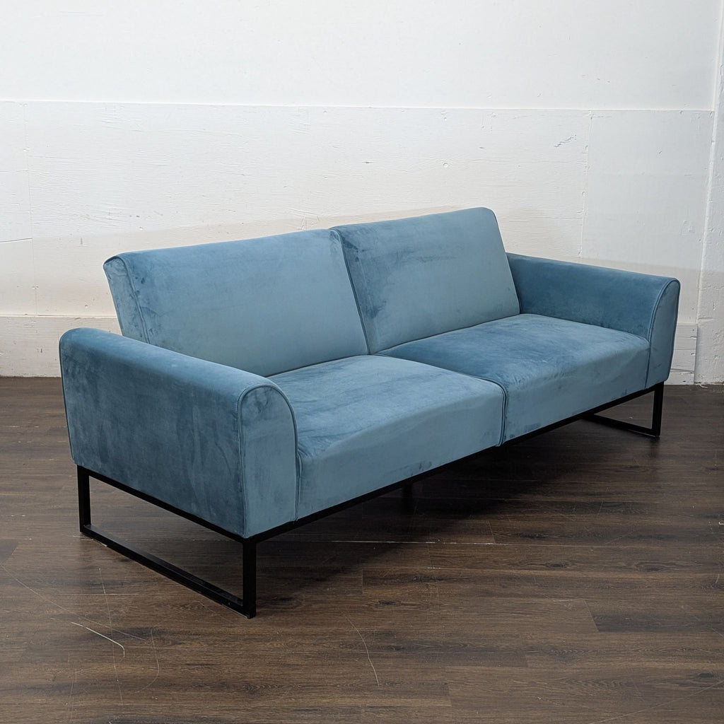 Full-size bed teal sofa with velvet upholstery and seating for three.
