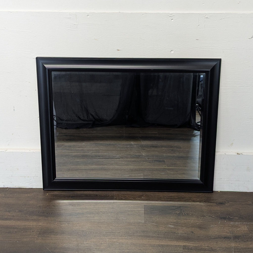 2. Set of two oversized mirrors with elegant frames, positioned against a neutral-colored wall.