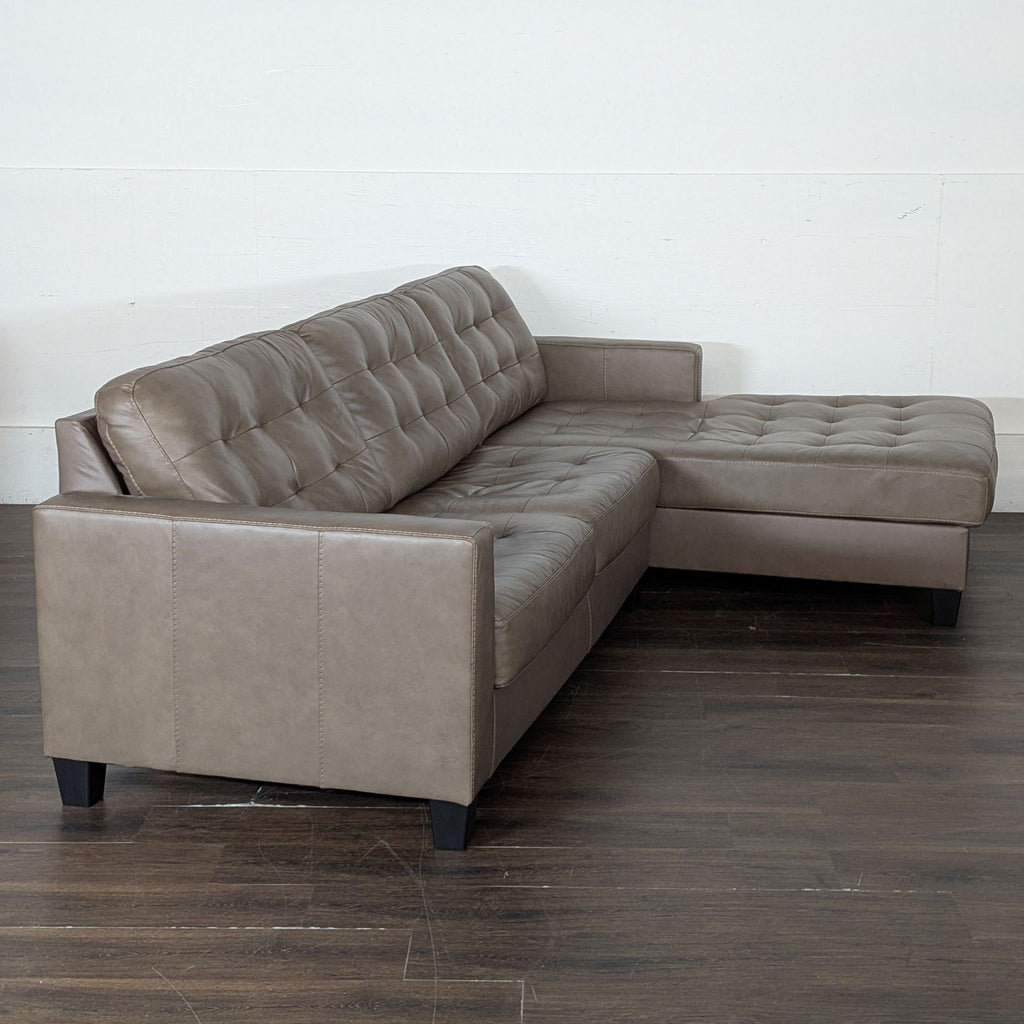 One-year-old brown leather sectional couch, comfortable and spacious for any decor.