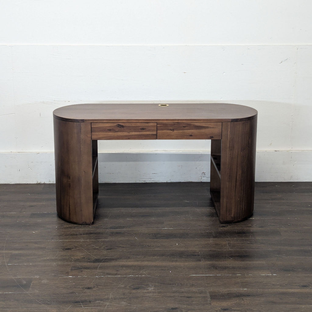 2. Dark wood desk featuring a smooth oval top, center drawer, and side shelving against a white wall.  