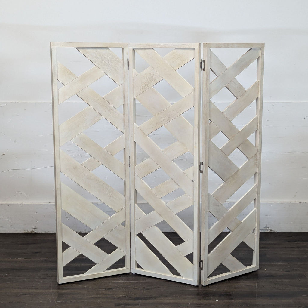 2. Freestanding three-panel wooden room divider with woven crisscross design and a light finish on a wood floor.